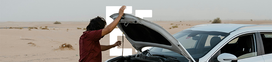 Man inspecting bonnet of car on the side of the road