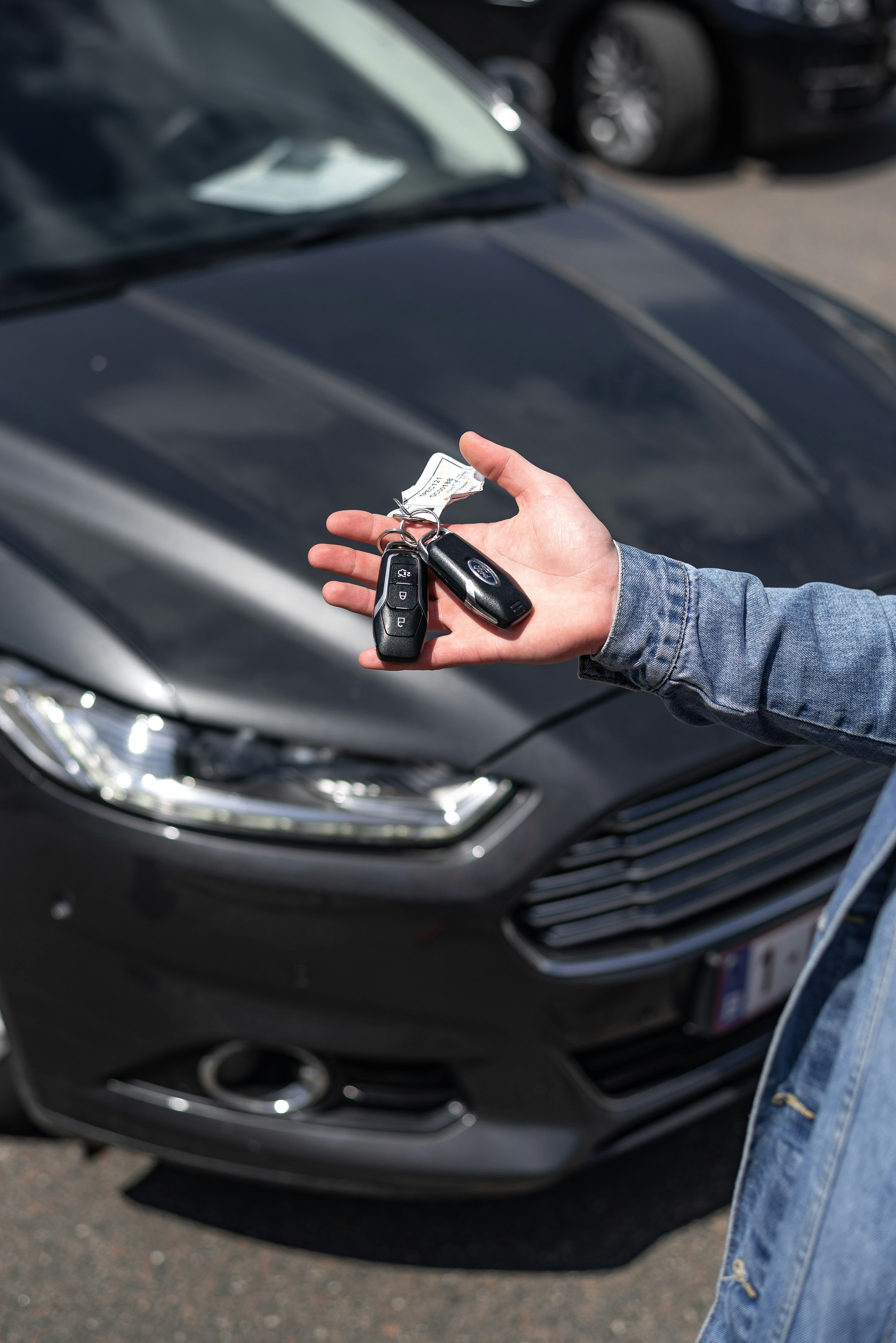 Car keys with black car in the background