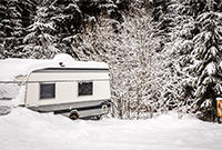 Caravan near snowy trees