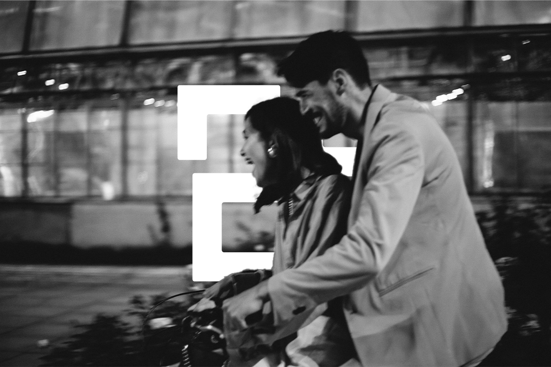 A couple on a bike laughing with Eversure logo